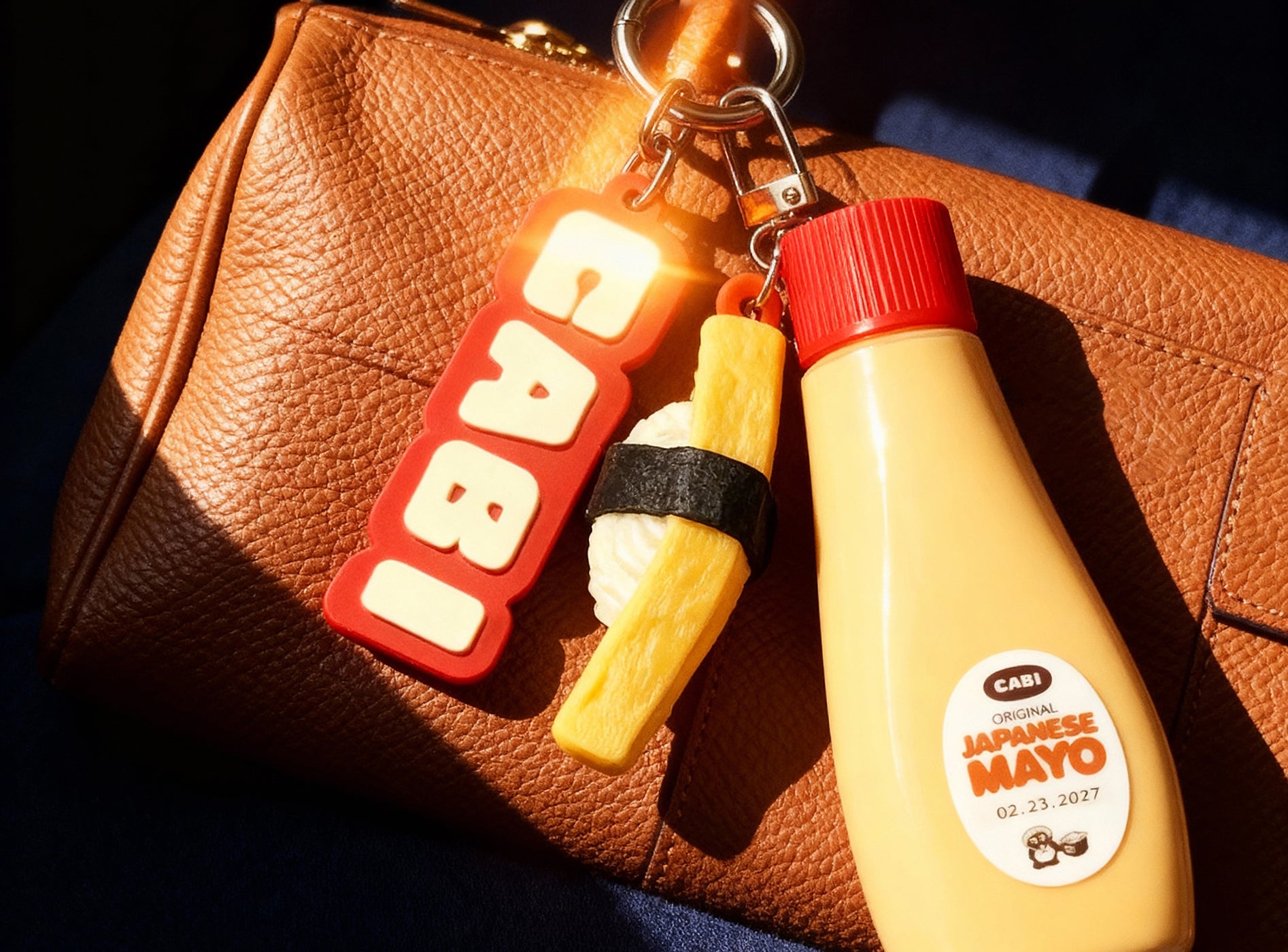Keychain with a bottle mayo on a brown leather surface.